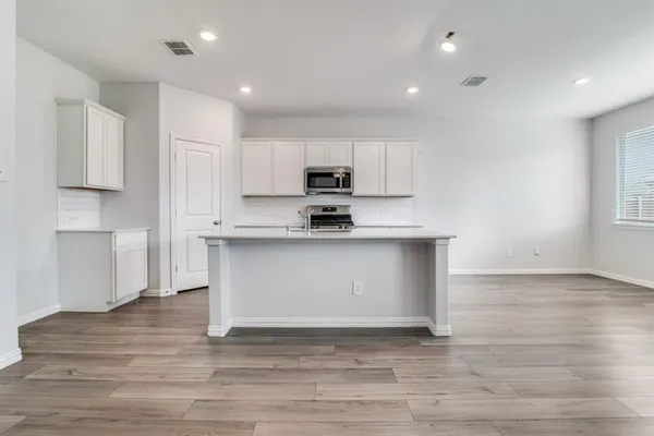 a kitchen with granite countertop white cabinets and stainless steel appliances