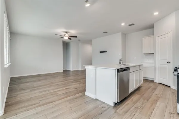 a kitchen with a sink cabinets and wooden floor