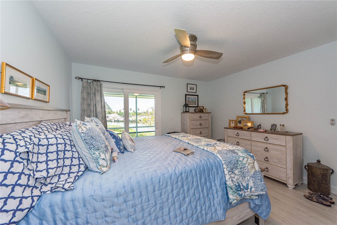 2800 Indian River Boulevard, Unit G6 Vero Beach, FL 32960 - Photo 11 of 22 a bedroom with a large bed and a chandelier