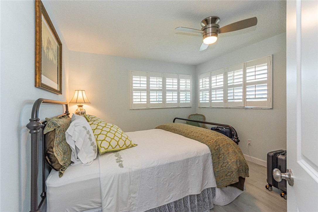 2800 Indian River Boulevard, Unit G6 Vero Beach, FL 32960 - Photo 16 of 22 a bedroom with a bed and a chandelier