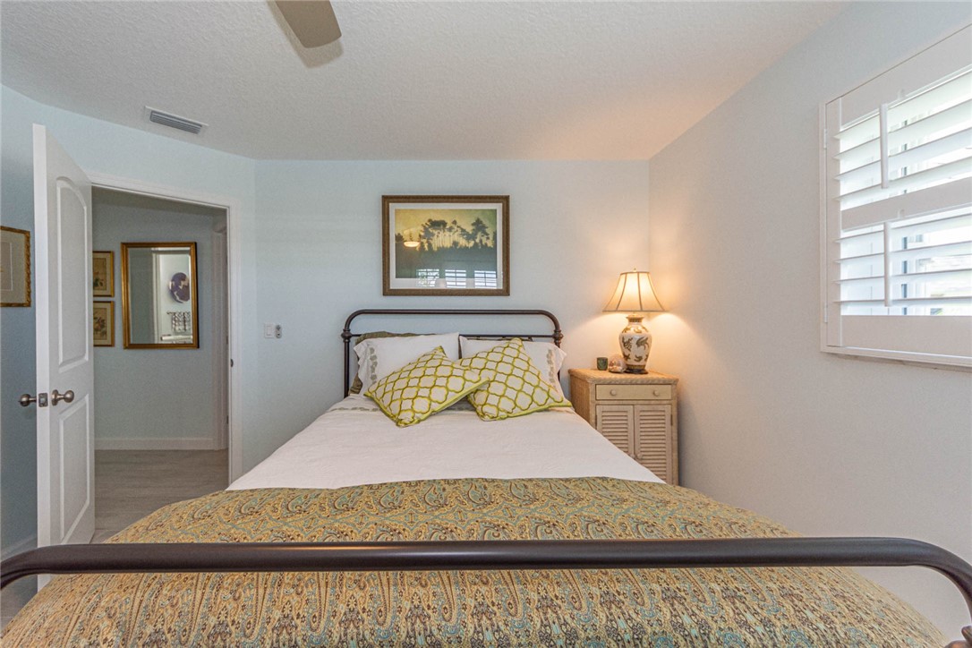2800 Indian River Boulevard, Unit G6 Vero Beach, FL 32960 - Photo 17 of 22 a bedroom with a bed and wooden floor