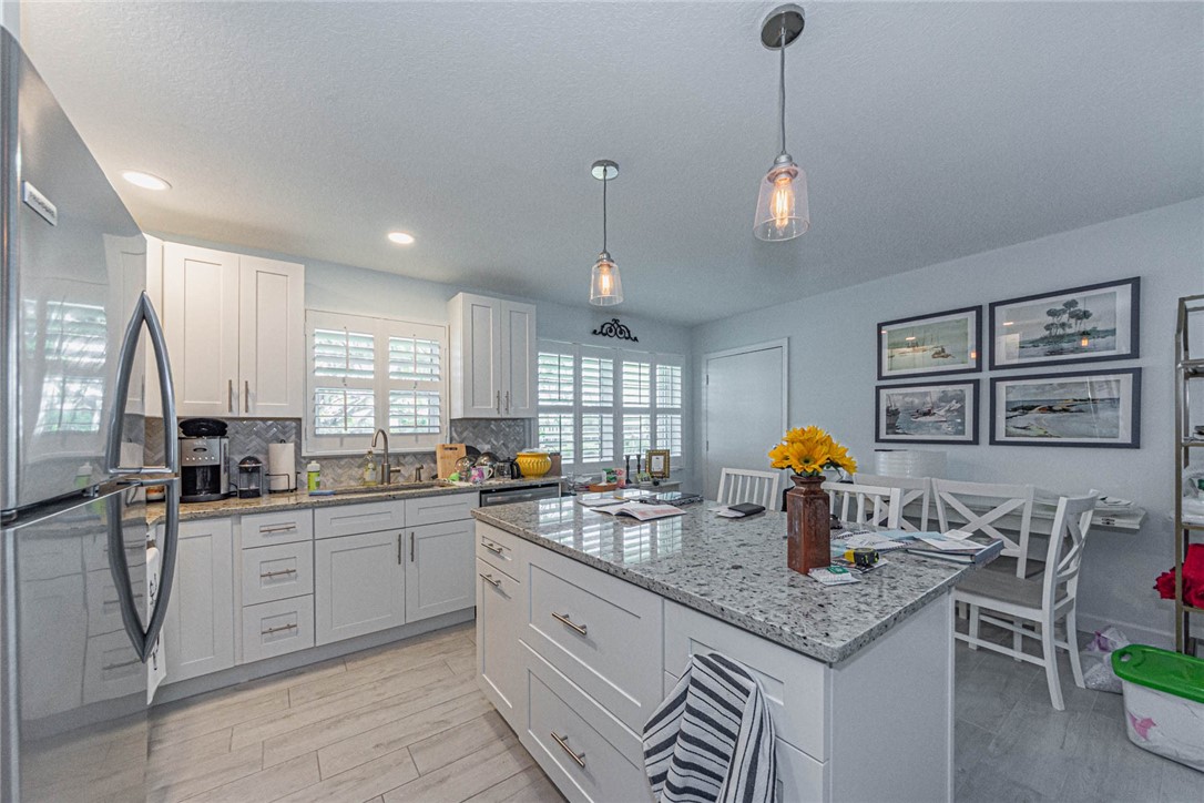 2800 Indian River Boulevard, Unit G6 Vero Beach, FL 32960 - Photo 8 of 22 a kitchen with stainless steel appliances granite countertop a sink and stove