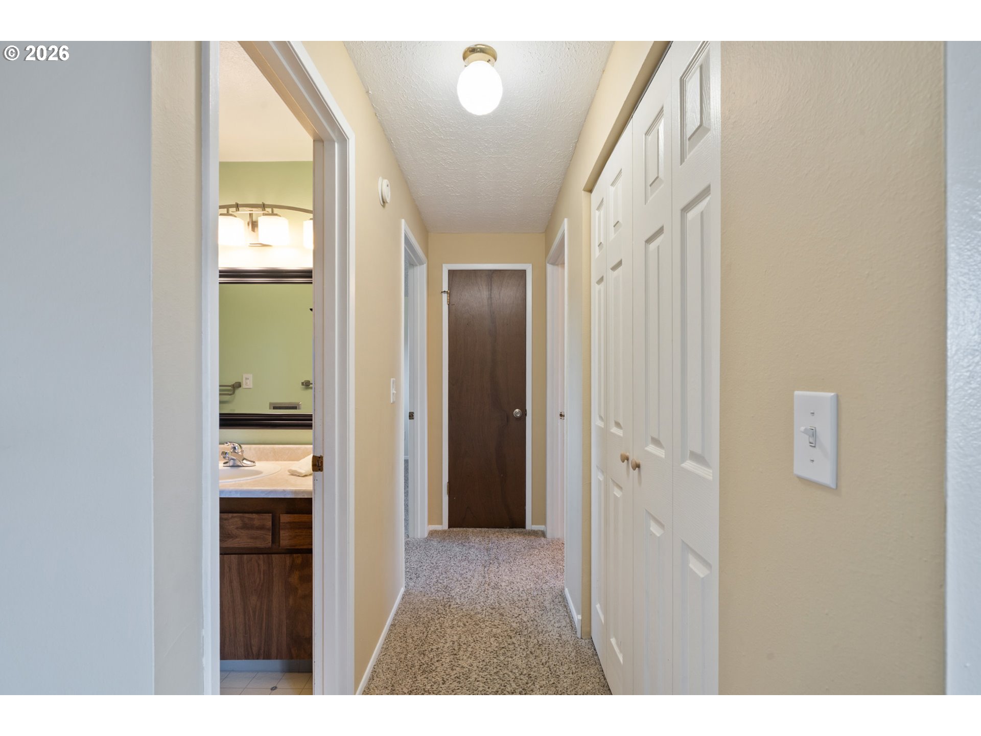 702 Ash Avenue Tillamook, OR 97141 - Photo 16 of 27 a view of a hallway with wooden floor and a bathroom