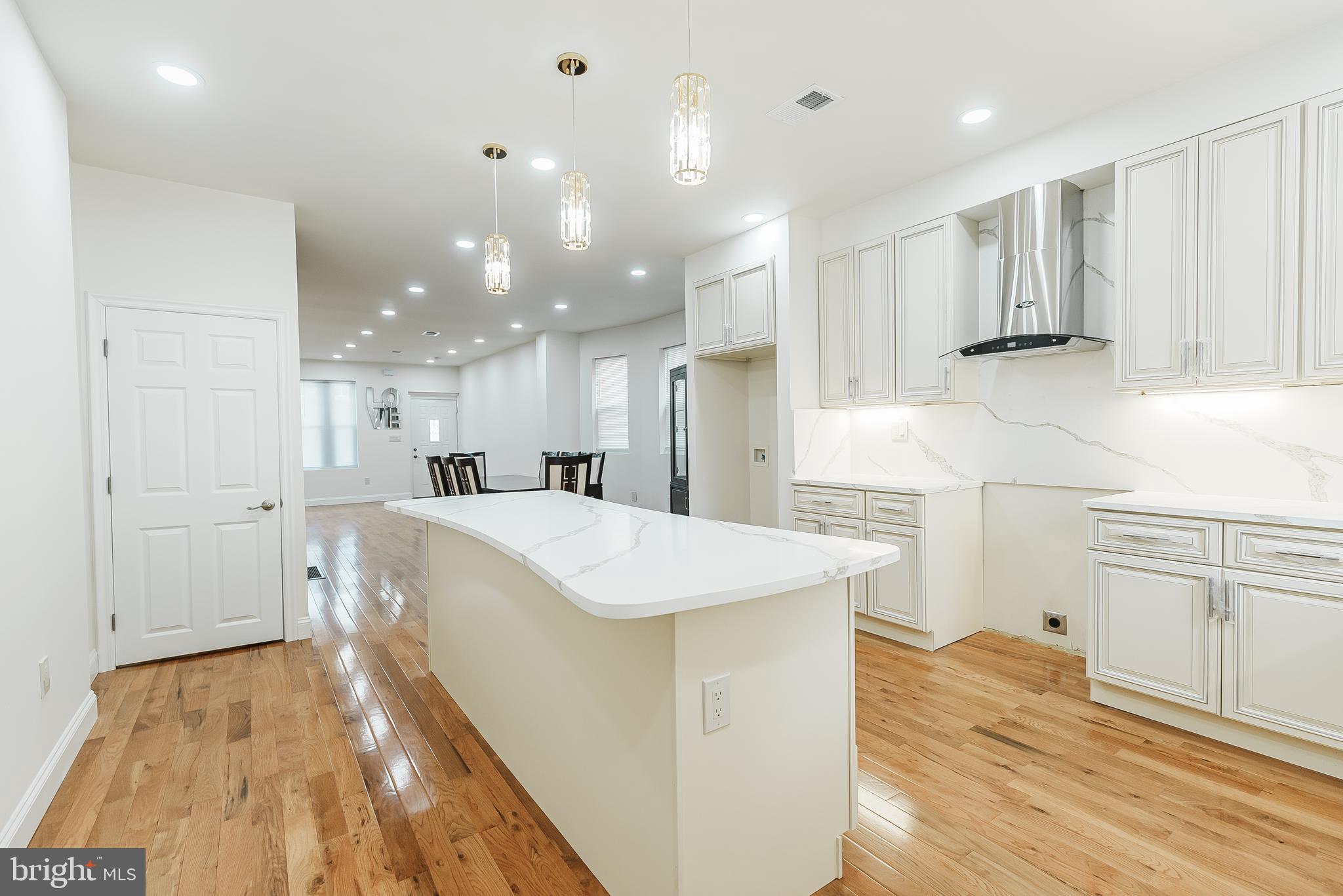 6357 Old York Road Philadelphia, PA 19141 - Photo 41 of 41 a kitchen with a sink a stove a refrigerator and white cabinets with wooden floor