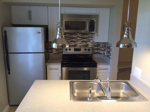 2814 Nueces Street, Unit 208 Austin, TX 78705 - Photo 2 of 6 a kitchen with granite countertop a refrigerator and a sink