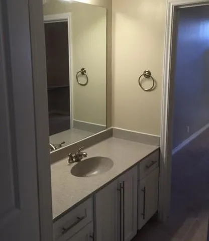 a bathroom with a granite countertop sink and a mirror