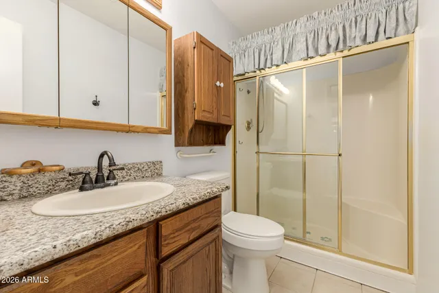 a bathroom with a granite countertop sink a mirror and a shower