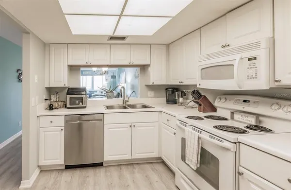a kitchen with cabinets appliances a sink and a counter top space