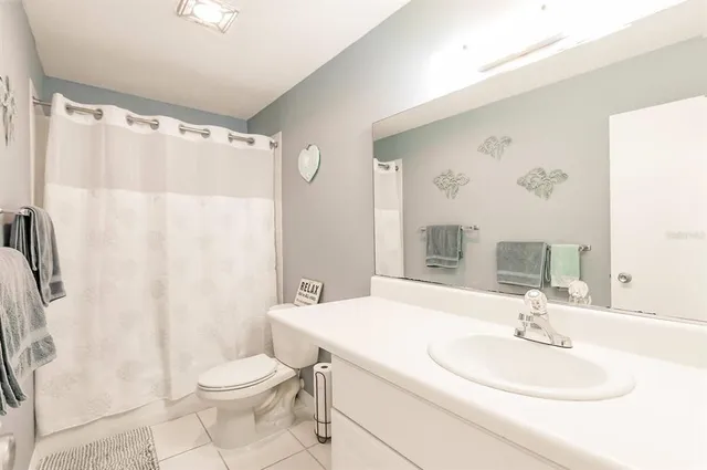 a bathroom with a sink a toilet and shower curtain