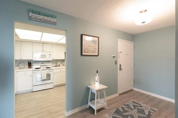 a kitchen with granite countertop white cabinets and white appliances