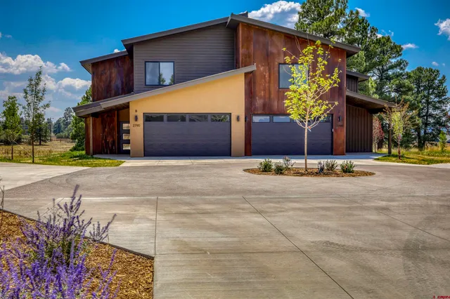 a view of a house with a yard and potted plants