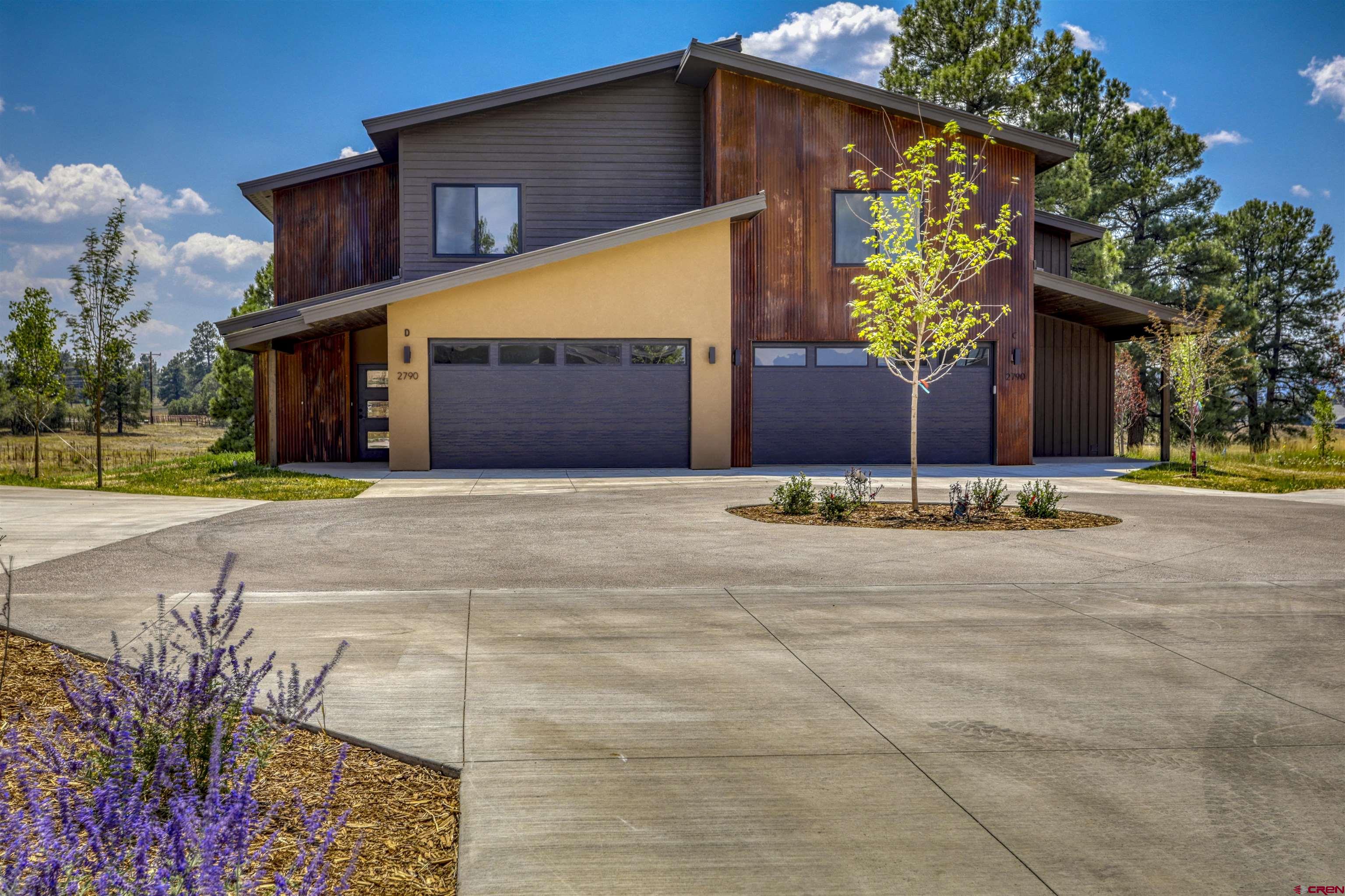 a view of a house with a yard and potted plants