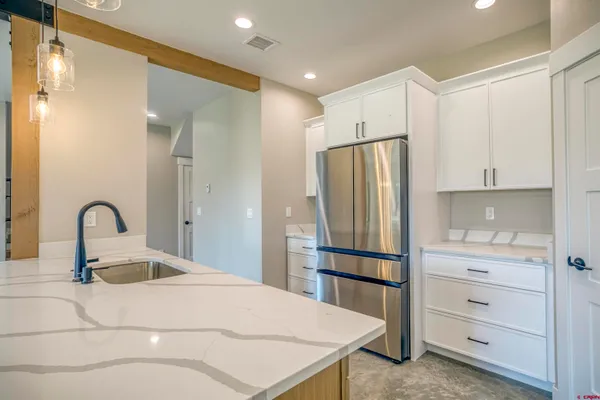 a view of a kitchen with a sink and chandelier