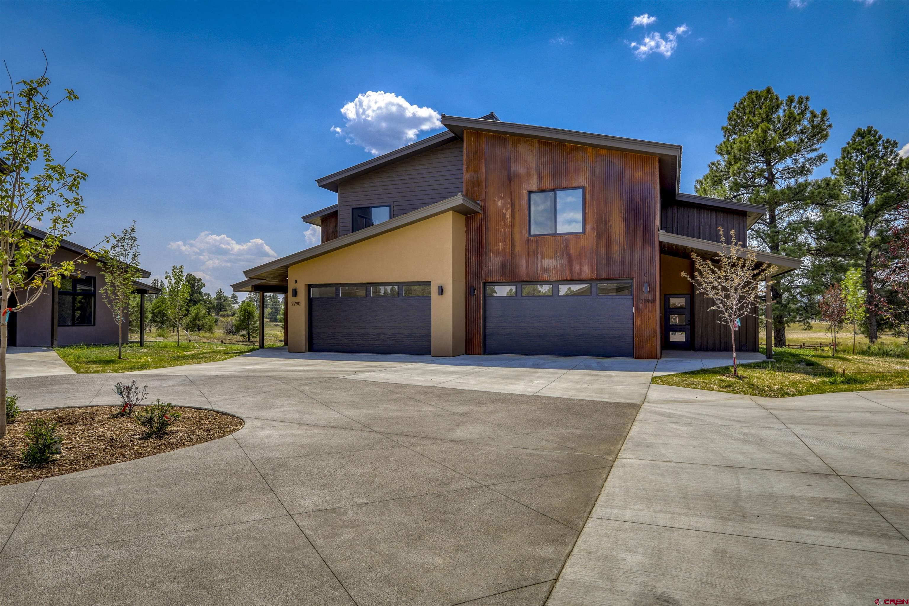 2790 Rock Road, Unit C Pagosa Springs, CO 81147 - Photo 2 of 44 a front view of a house with a yard and garage
