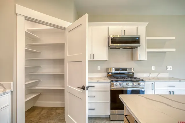 a kitchen with stainless steel appliances granite countertop a sink a stove and a wooden floors