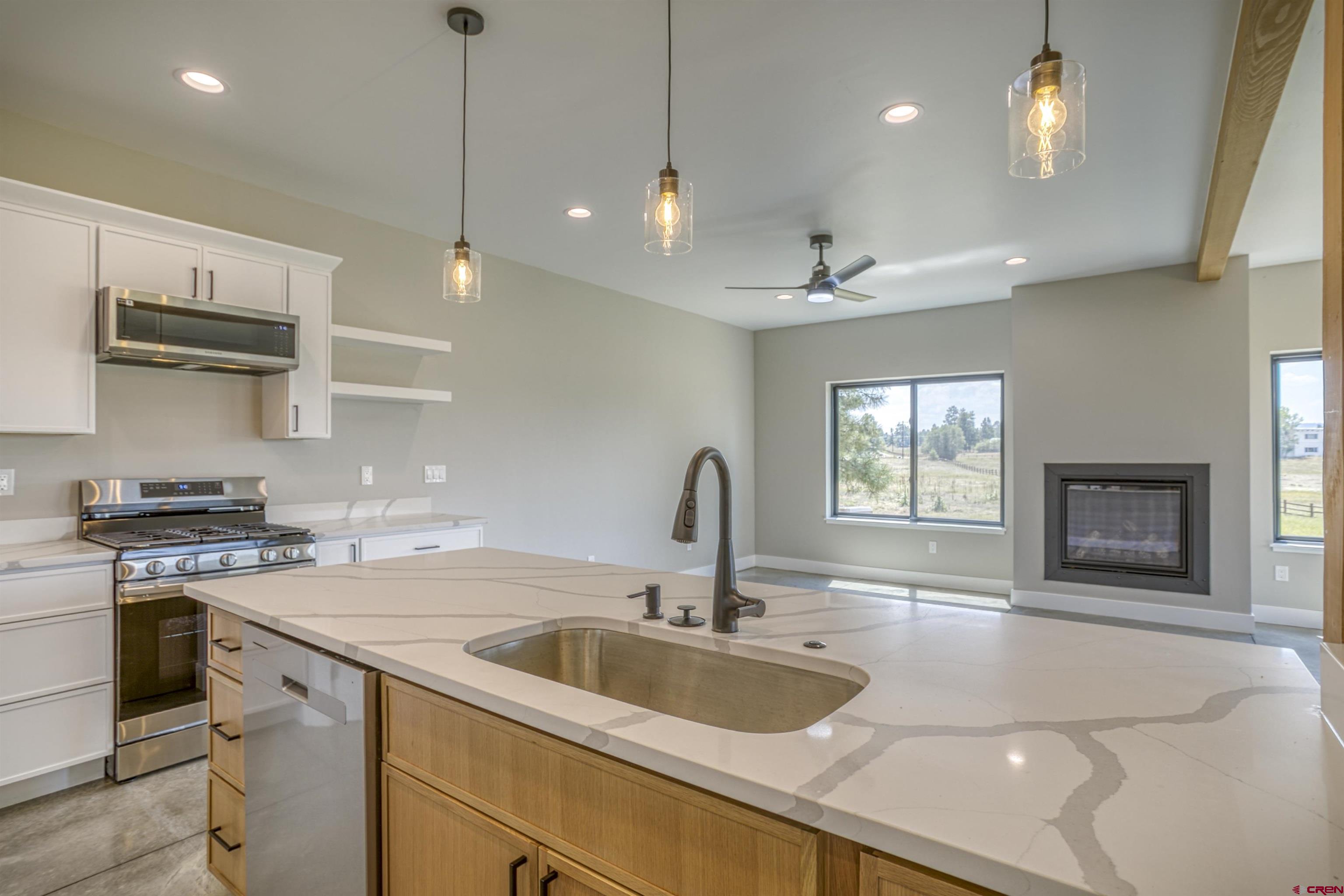 2790 Rock Road, Unit C Pagosa Springs, CO 81147 - Photo 23 of 44 a kitchen with stainless steel appliances granite countertop a sink a stove and a wooden floors