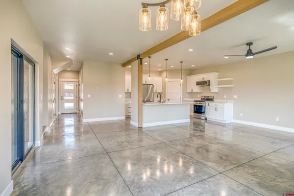 a large kitchen with stainless steel appliances kitchen island granite countertop a large counter top a stove a sink and a refrigerator