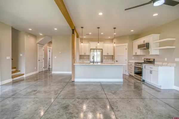 a kitchen with kitchen island a sink stainless steel appliances and refrigerator