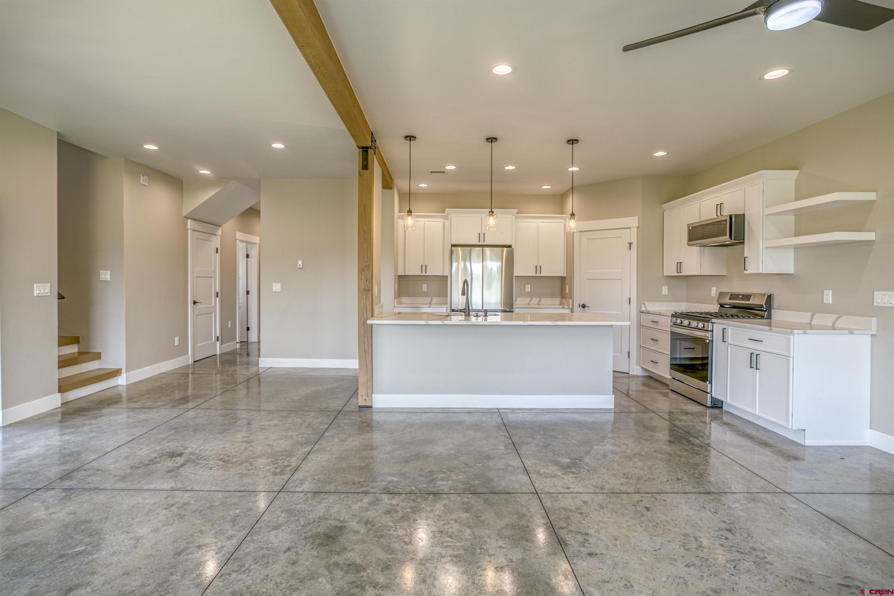 2790 Rock Road, Unit C Pagosa Springs, CO 81147 - Photo 27 of 44 a large kitchen with stainless steel appliances kitchen island granite countertop a large counter top a stove a sink and a refrigerator