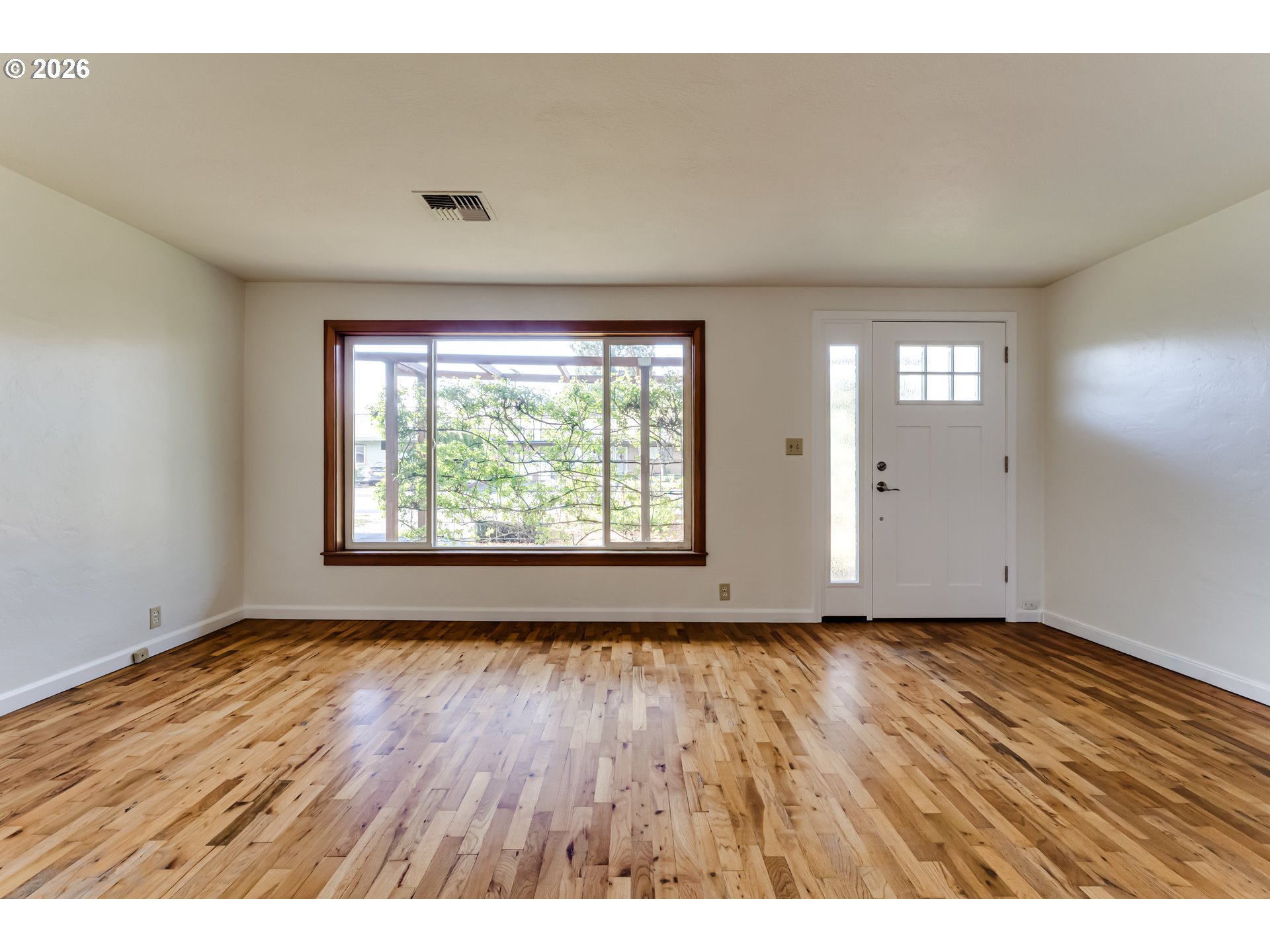 2125 West 19th Place Eugene, OR 97405 - Photo 11 of 29 wooden floor in an empty room with a window