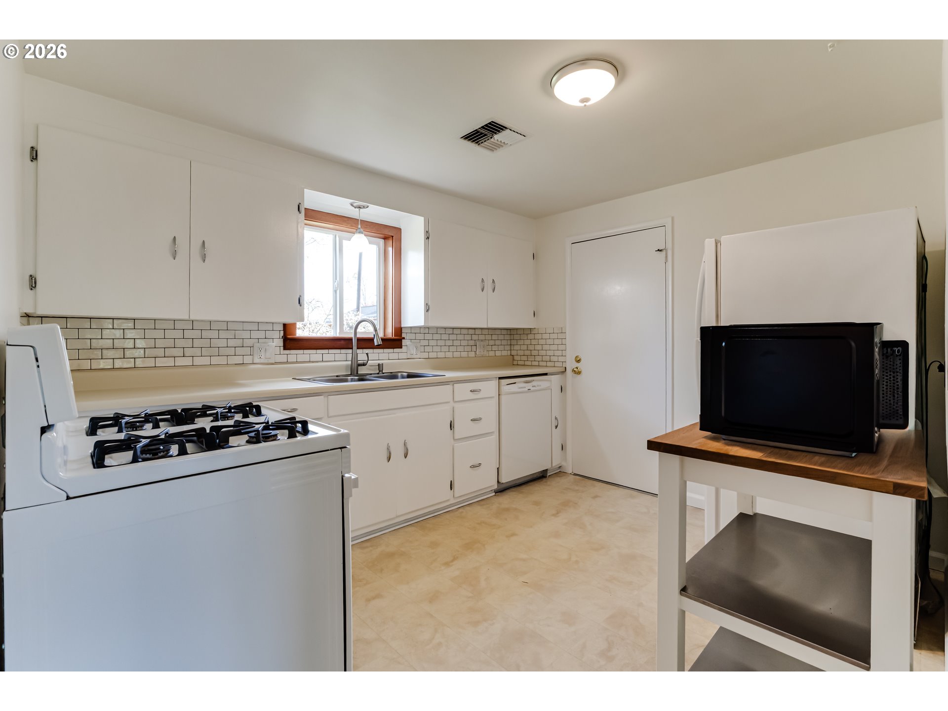 2125 West 19th Place Eugene, OR 97405 - Photo 16 of 29 a kitchen with a stove a sink and a microwave