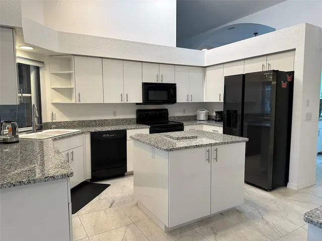 a kitchen with stainless steel appliances granite countertop a refrigerator and a stove top oven