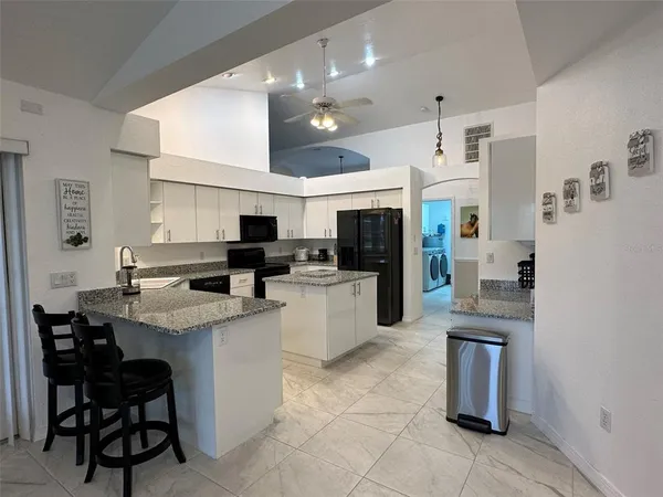 a kitchen with cabinets and chairs