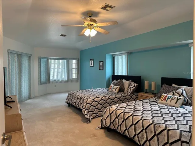 a bedroom with two beds and a chandelier