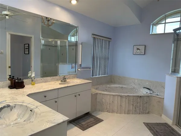 a bathroom with a tub sink and mirror