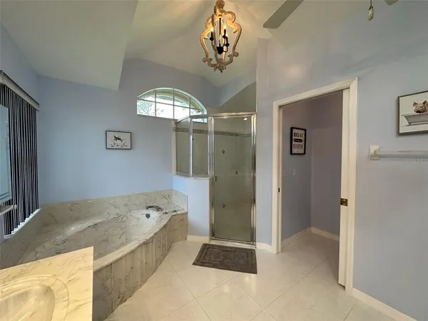 a spacious bathroom with a tub shower and view of bathroom