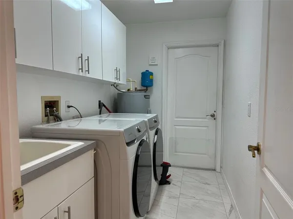 a utility room with sink dryer and washer