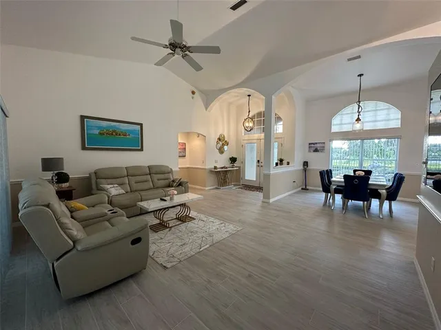 a living room with furniture dining area and a chandelier