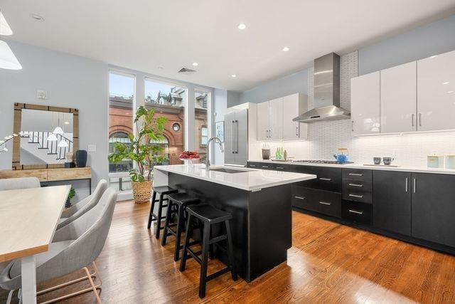 a kitchen with stainless steel appliances granite countertop table chairs sink and cabinets
