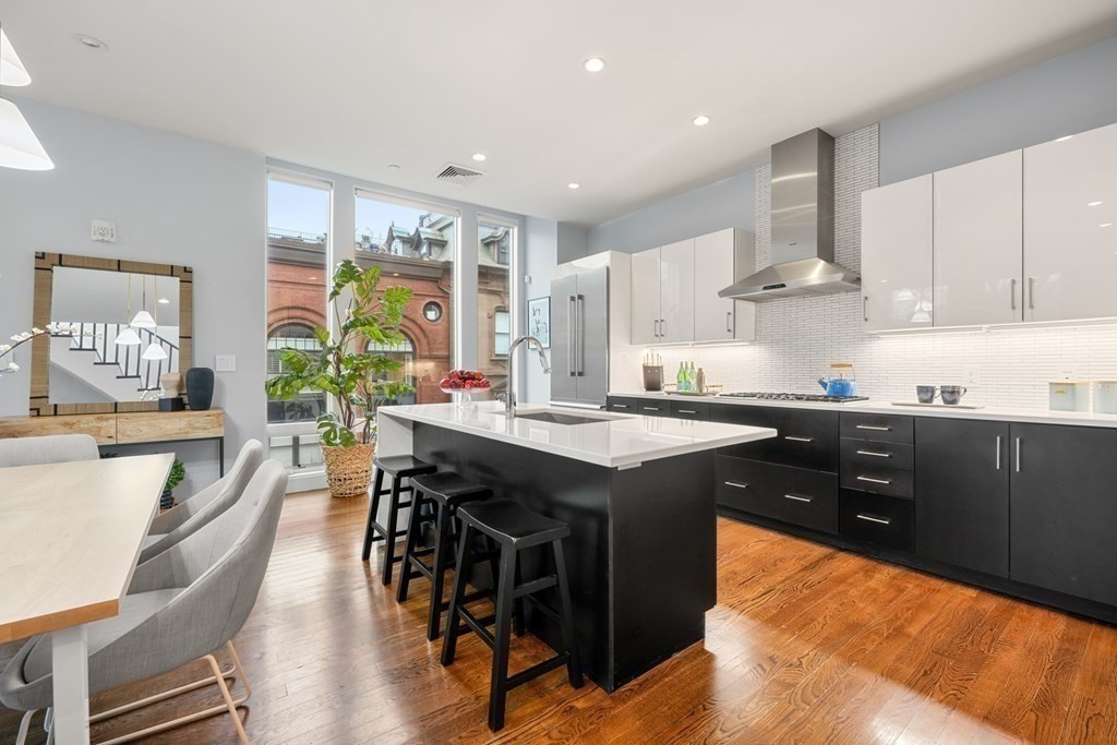 1672 R Washington Street, Unit TH1 Boston, MA 02118 - Photo 15 of 40 a kitchen with stainless steel appliances granite countertop table chairs sink and cabinets