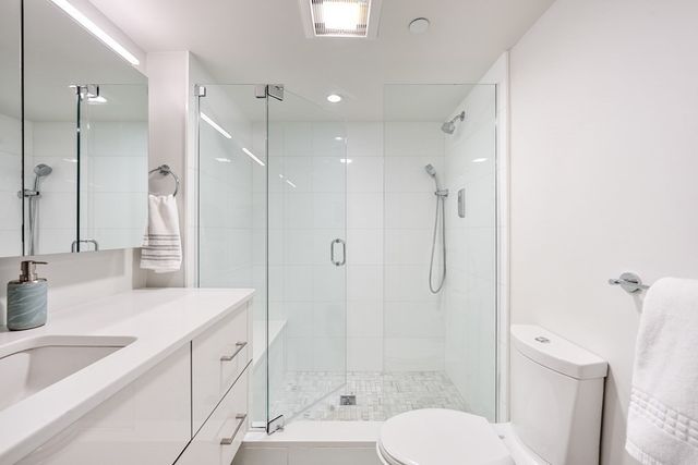 a bathroom with a granite countertop sink toilet a shower and a mirror