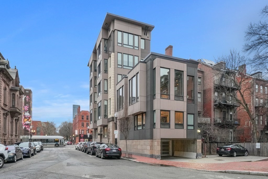 1672 R Washington Street, Unit TH1 Boston, MA 02118 - Photo 36 of 40 a front view of a building with lot of cars and trees