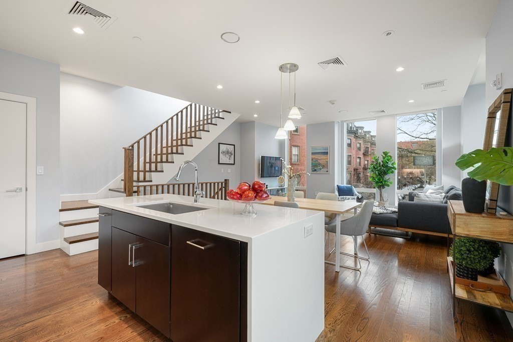 1672 R Washington Street, Unit TH1 Boston, MA 02118 - Photo 7 of 40 a view of a living room and kitchen with furniture wooden floor and windows