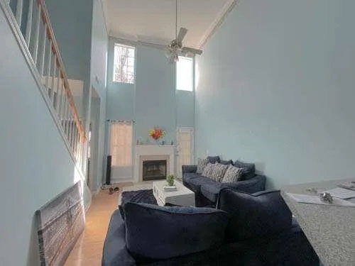 a living room with furniture a fireplace and a chandelier
