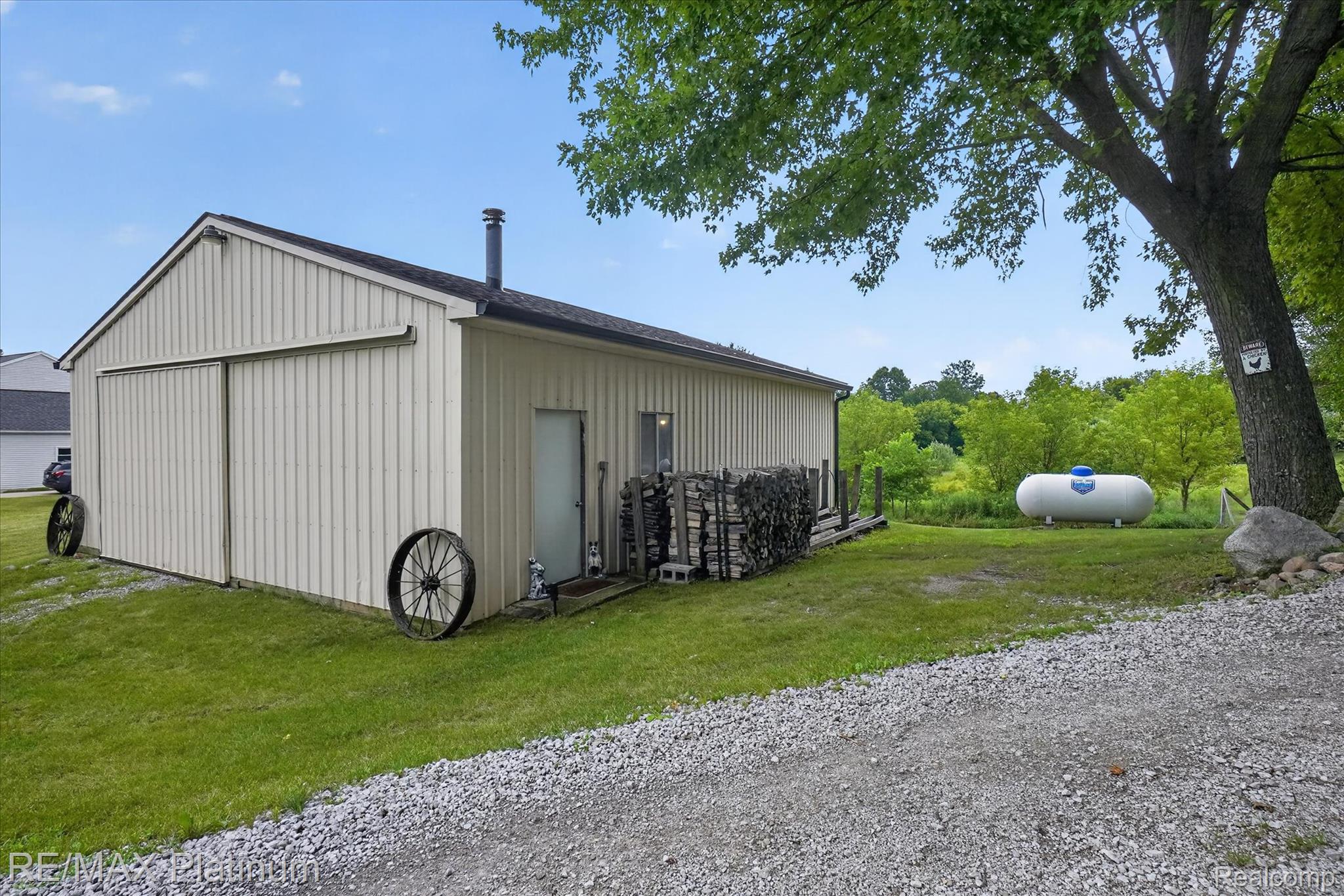 4457 Bradley Road Gregory, MI 48137 - Photo 47 of 79 Detached outbuilding with vertical siding, a sliding barn door, and a separate entry door