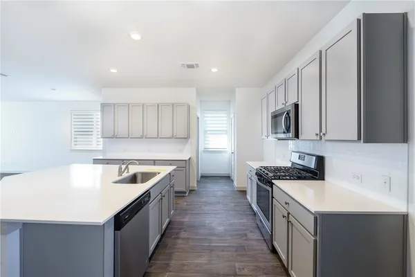 a kitchen with a sink stove and cabinets