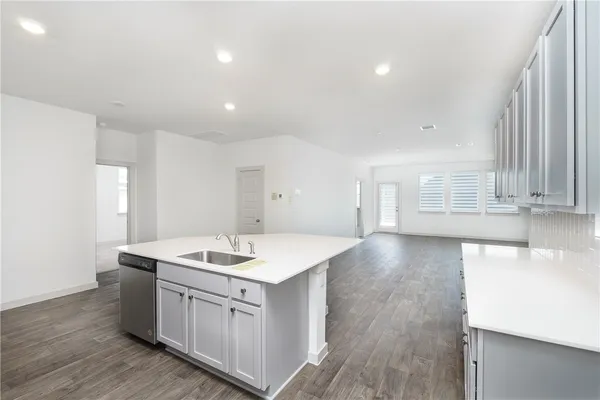 a view of kitchen with sink wooden floor and windows