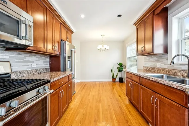 a kitchen with stainless steel appliances granite countertop wooden cabinets stove top oven and sink