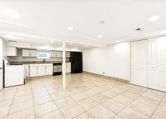 a view of a kitchen with a sink and an empty room