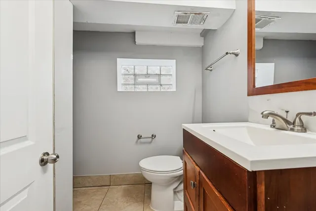 a bathroom with a sink a toilet and a mirror