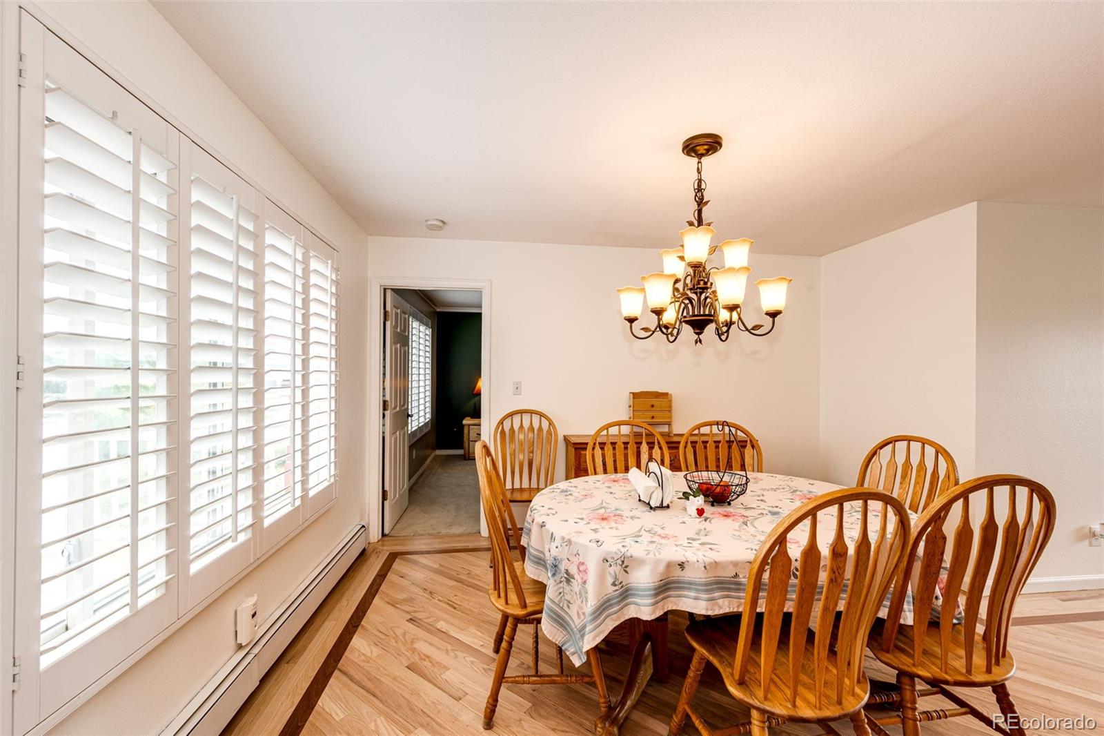 2218 Deerpath Road Franktown, CO 80116 - Photo 11 of 46 a dining room with furniture a chandelier and wooden floor
