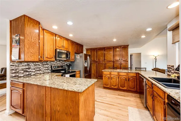 a kitchen with stainless steel appliances granite countertop sink stove and refrigerator