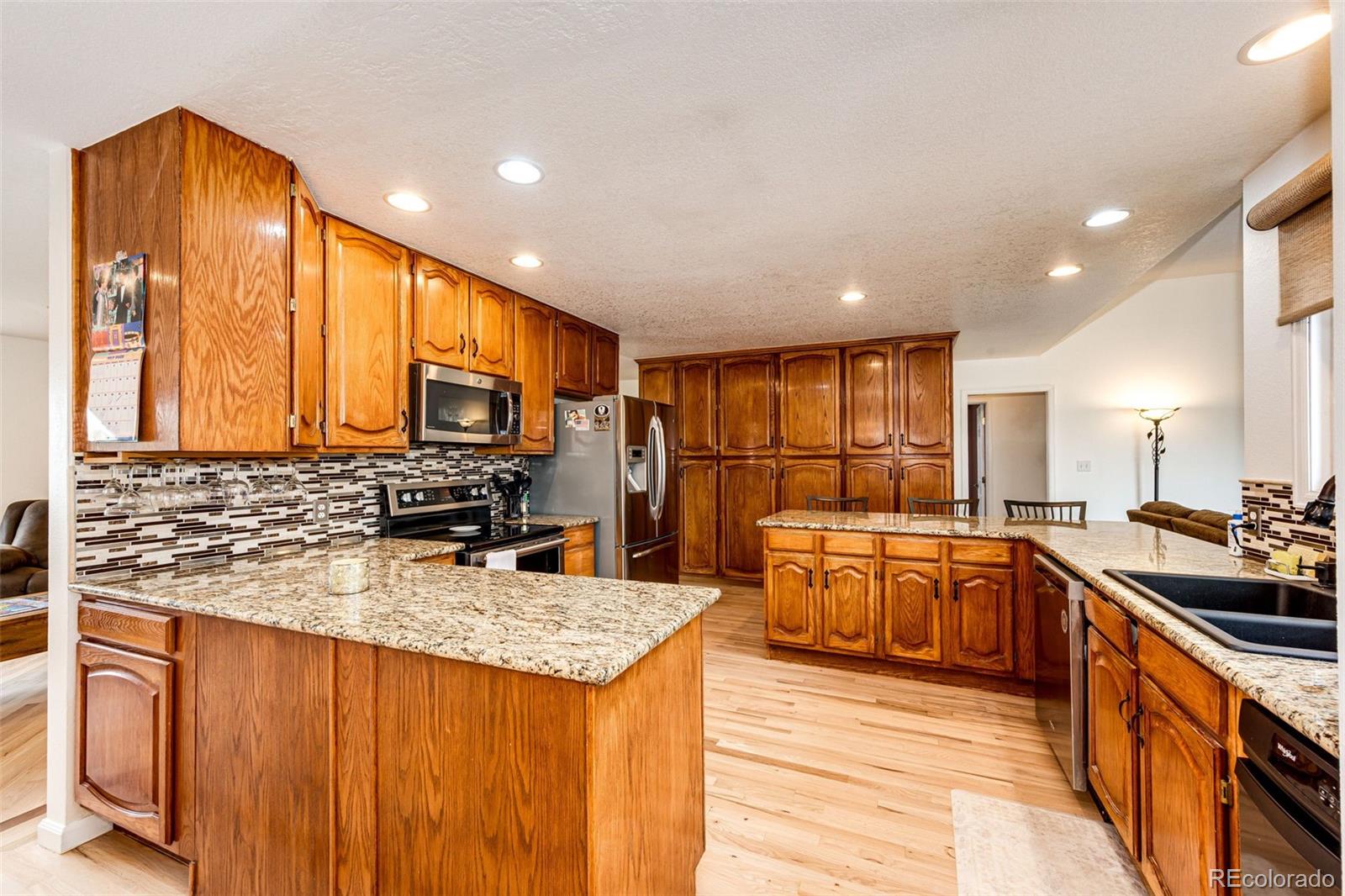 2218 Deerpath Road Franktown, CO 80116 - Photo 12 of 46 a kitchen with stainless steel appliances granite countertop sink stove and refrigerator