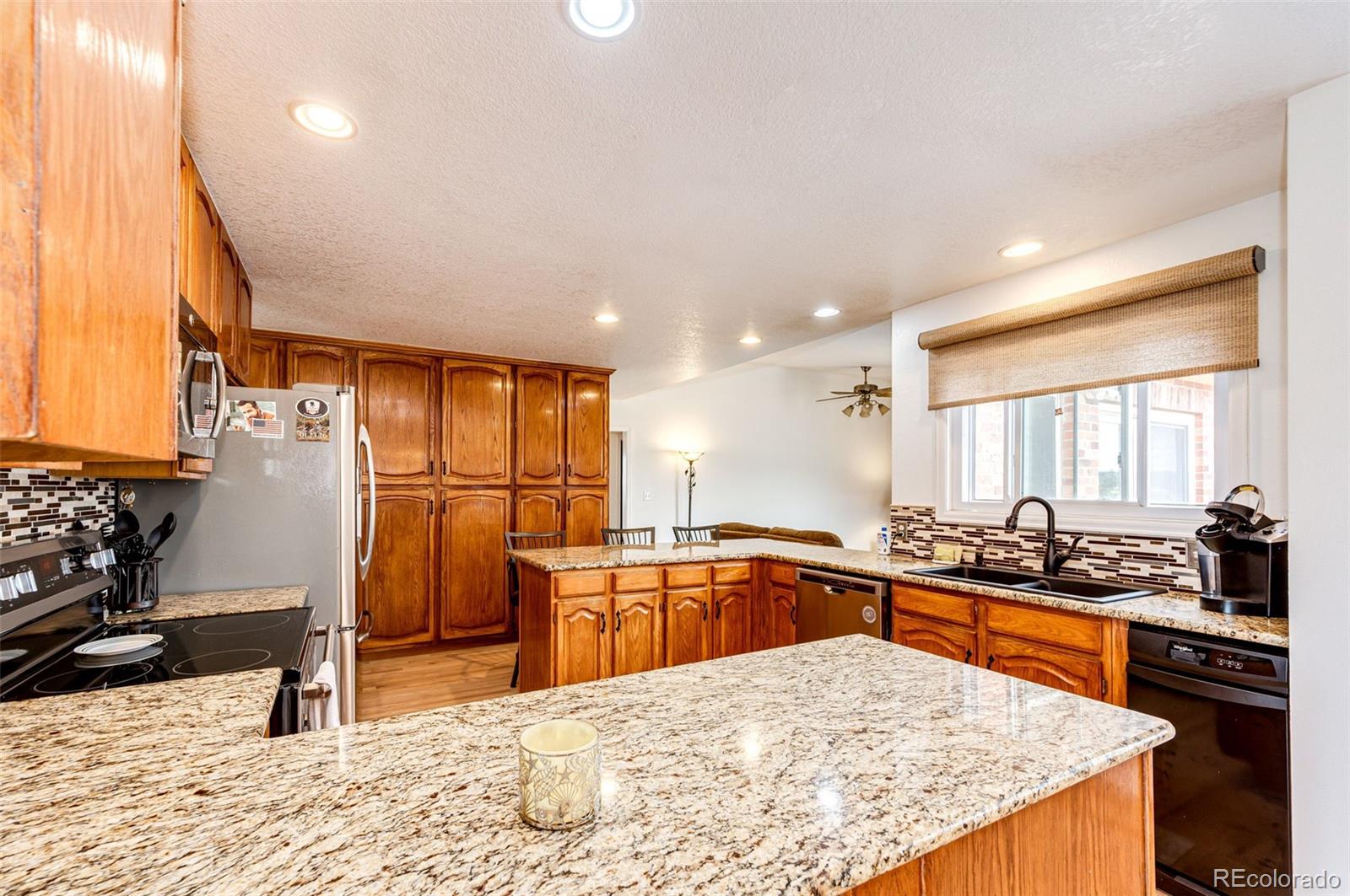 2218 Deerpath Road Franktown, CO 80116 - Photo 13 of 46 a kitchen with stainless steel appliances granite countertop a sink stove and refrigerator