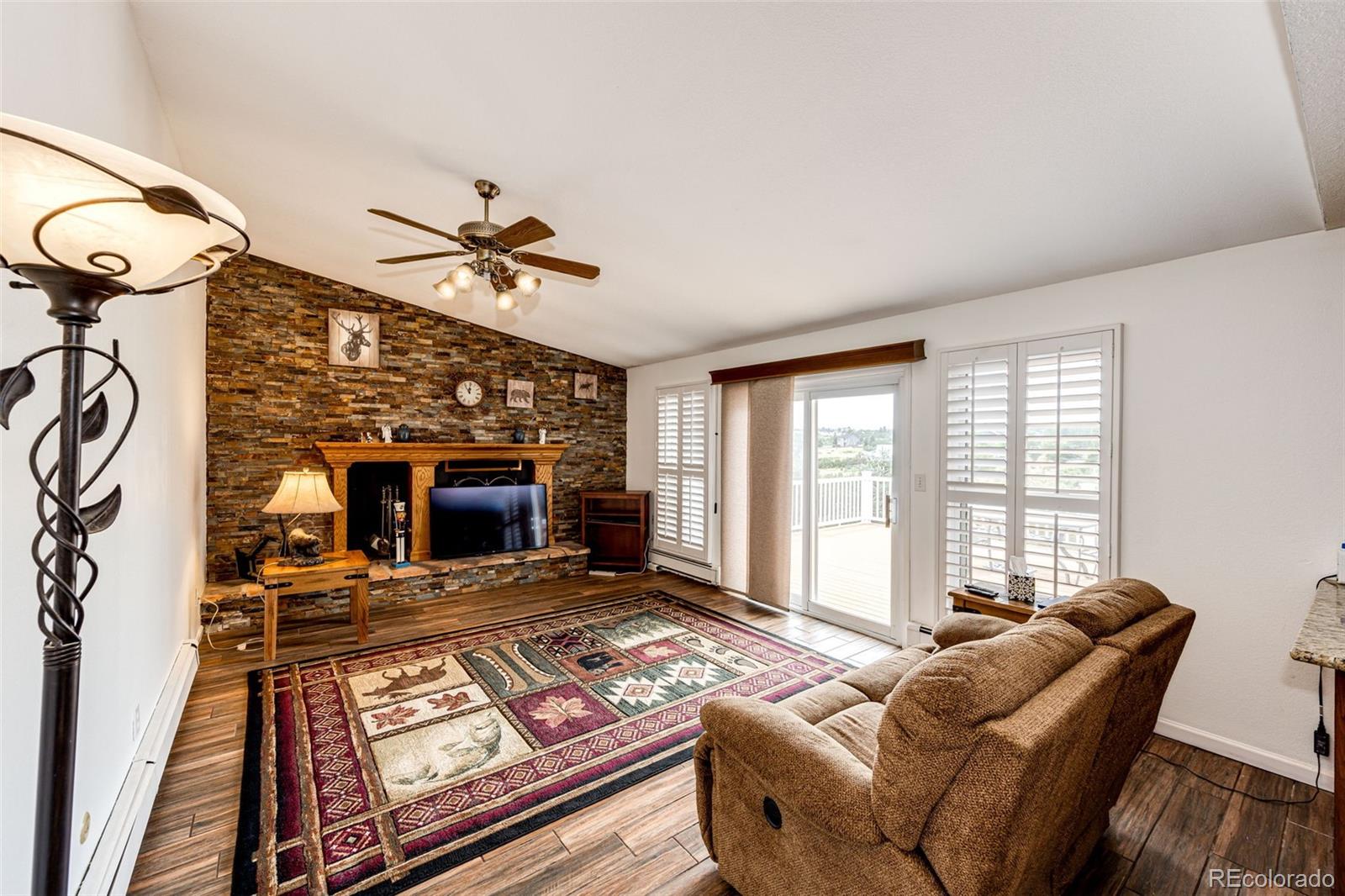 2218 Deerpath Road Franktown, CO 80116 - Photo 16 of 46 a living room with furniture a fireplace and a flat screen tv