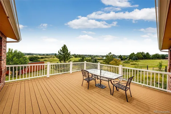 a balcony with wooden floor table and chairs